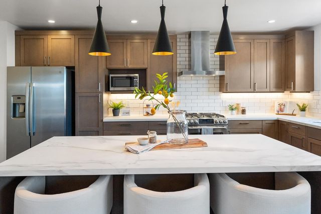 a kitchen with a sink a kitchen island and stainless steel appliances