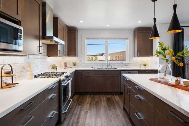 a kitchen with a sink stove and wooden floor