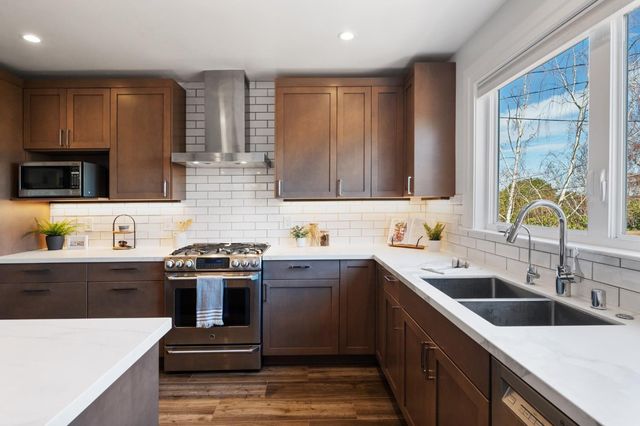 a kitchen with a sink stove top oven and refrigerator