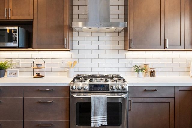 a kitchen with granite countertop a sink a stove and cabinets