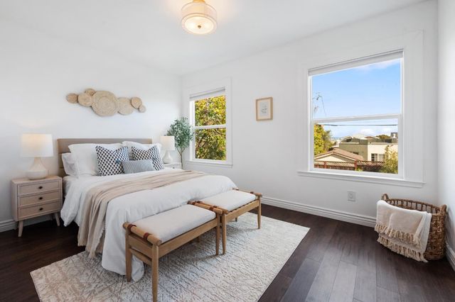 a bedroom with a bed and painting on the wall