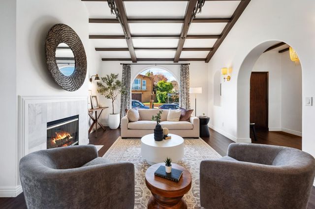 a living room with furniture a fireplace and a floor to ceiling window