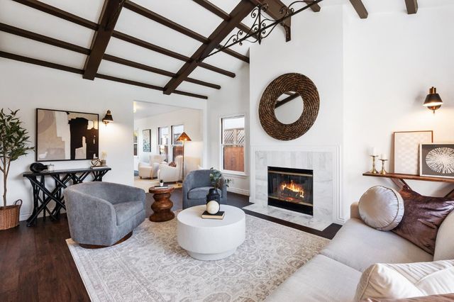 a living room with furniture a fireplace and wooden floor