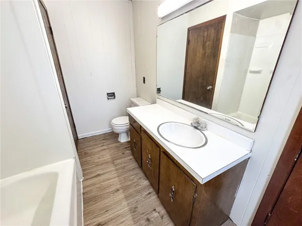 a bathroom with a tub sink and mirror