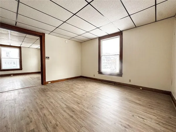 a view of empty room with wooden floor and fan