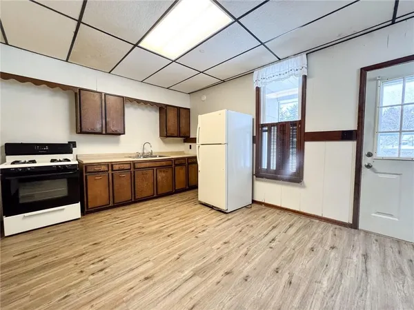 a kitchen with stainless steel appliances a refrigerator a sink a stove a microwave and cabinets