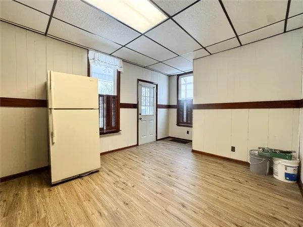 a view of an empty room with wooden floor and windows