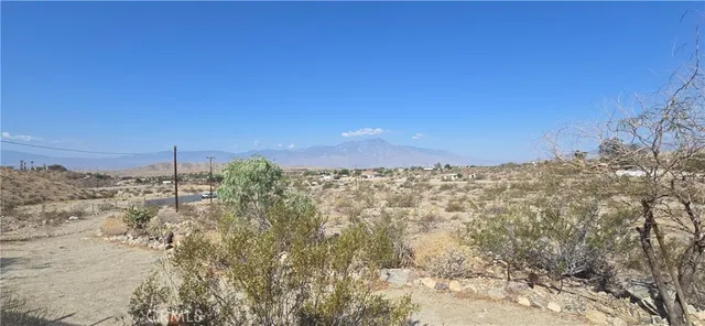 a view of a dry yard with mountains in the background