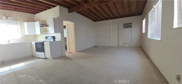 a view of a kitchen with refrigerator and windows