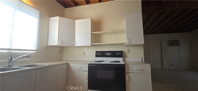 a kitchen with stainless steel appliances a sink stove and cabinets