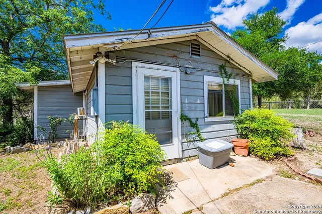 a view of a house with chair and potted plants