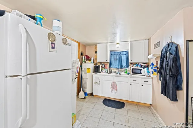 a white refrigerator freezer and a stove sitting inside of a kitchen