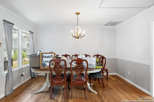 a dining room with furniture a chandelier and wooden floor