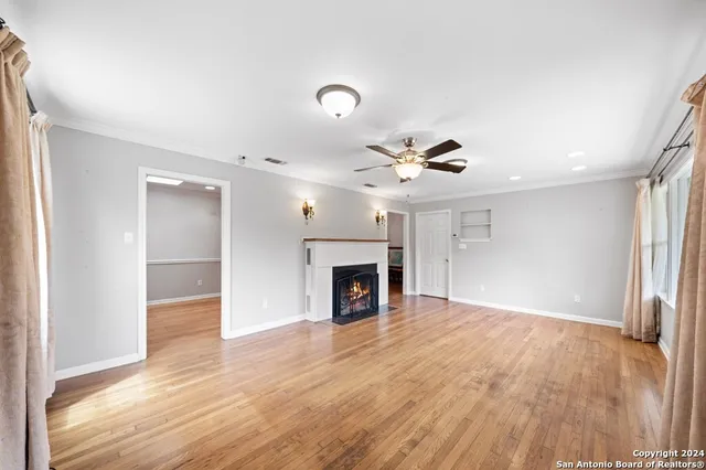 a view of a livingroom with a fireplace wooden floor and chandelier