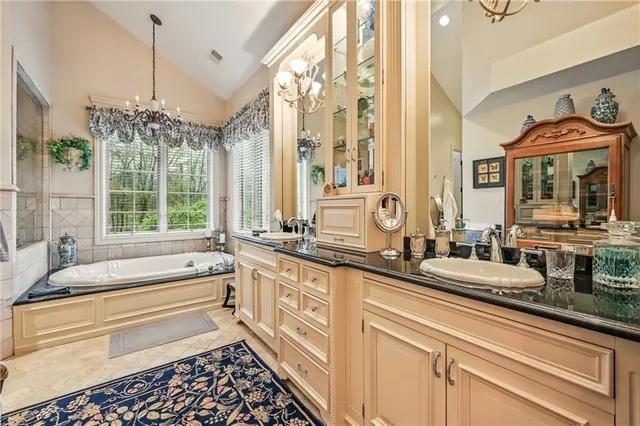 a bathroom with a double vanity sink large mirror and a large window