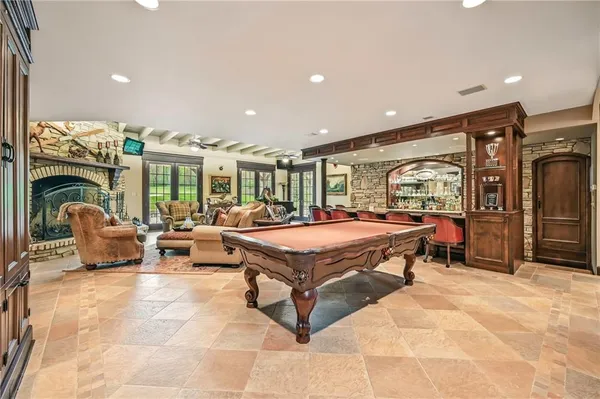 a living room with furniture a large pool table and chairs