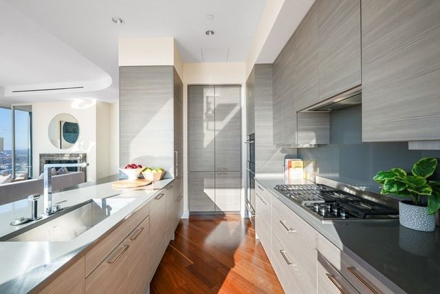 a large white kitchen with a large window and stainless steel appliances