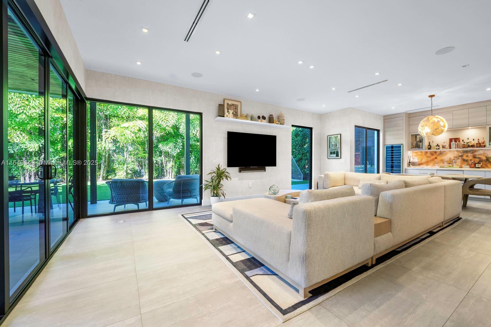 7900 Southwest 54th Avenue Miami, FL 33143 - Photo 16 of 63 a living room with furniture a flat screen tv and a floor to ceiling window