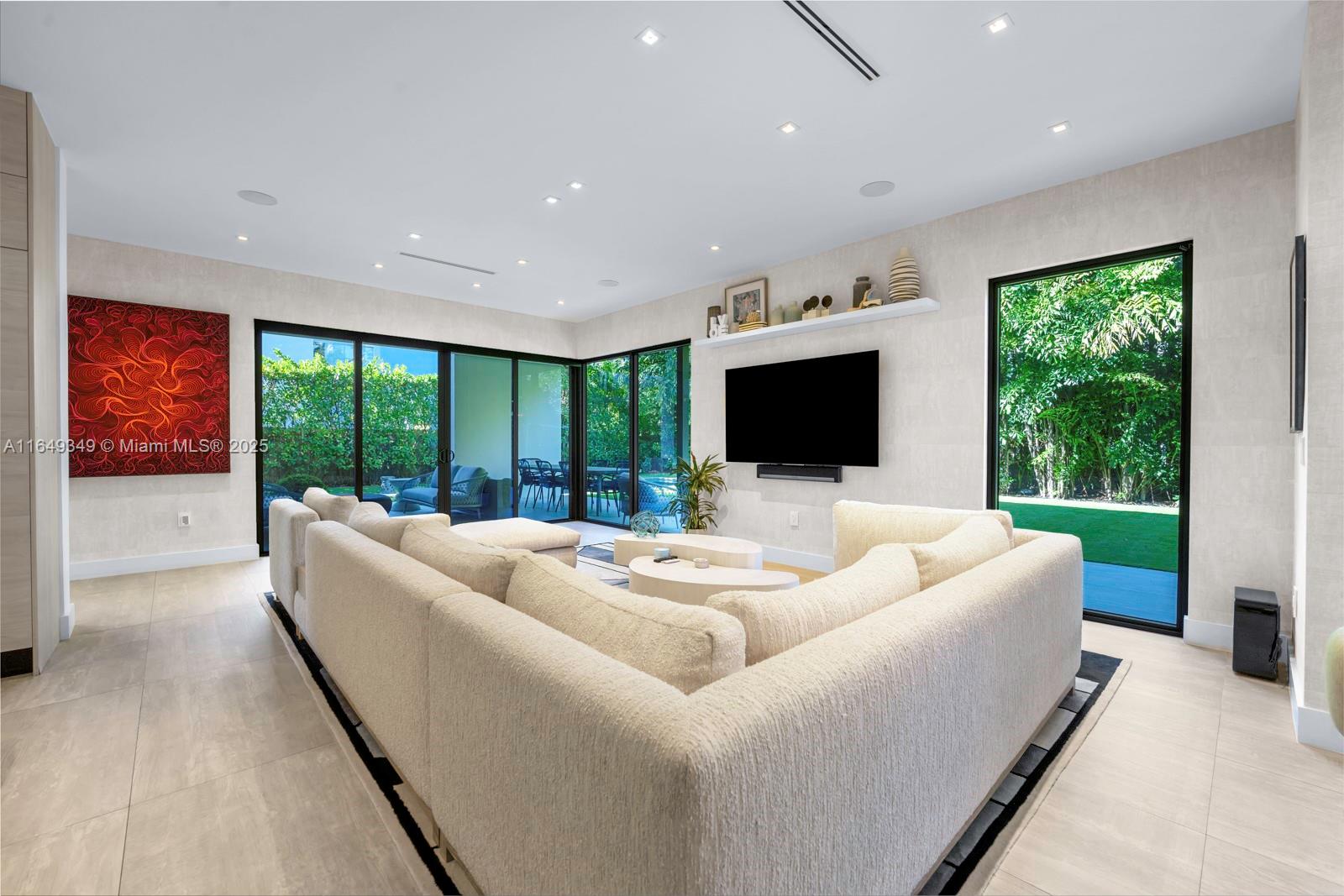 7900 Southwest 54th Avenue Miami, FL 33143 - Photo 22 of 63 a living room with furniture floor to ceiling window and a flat screen tv