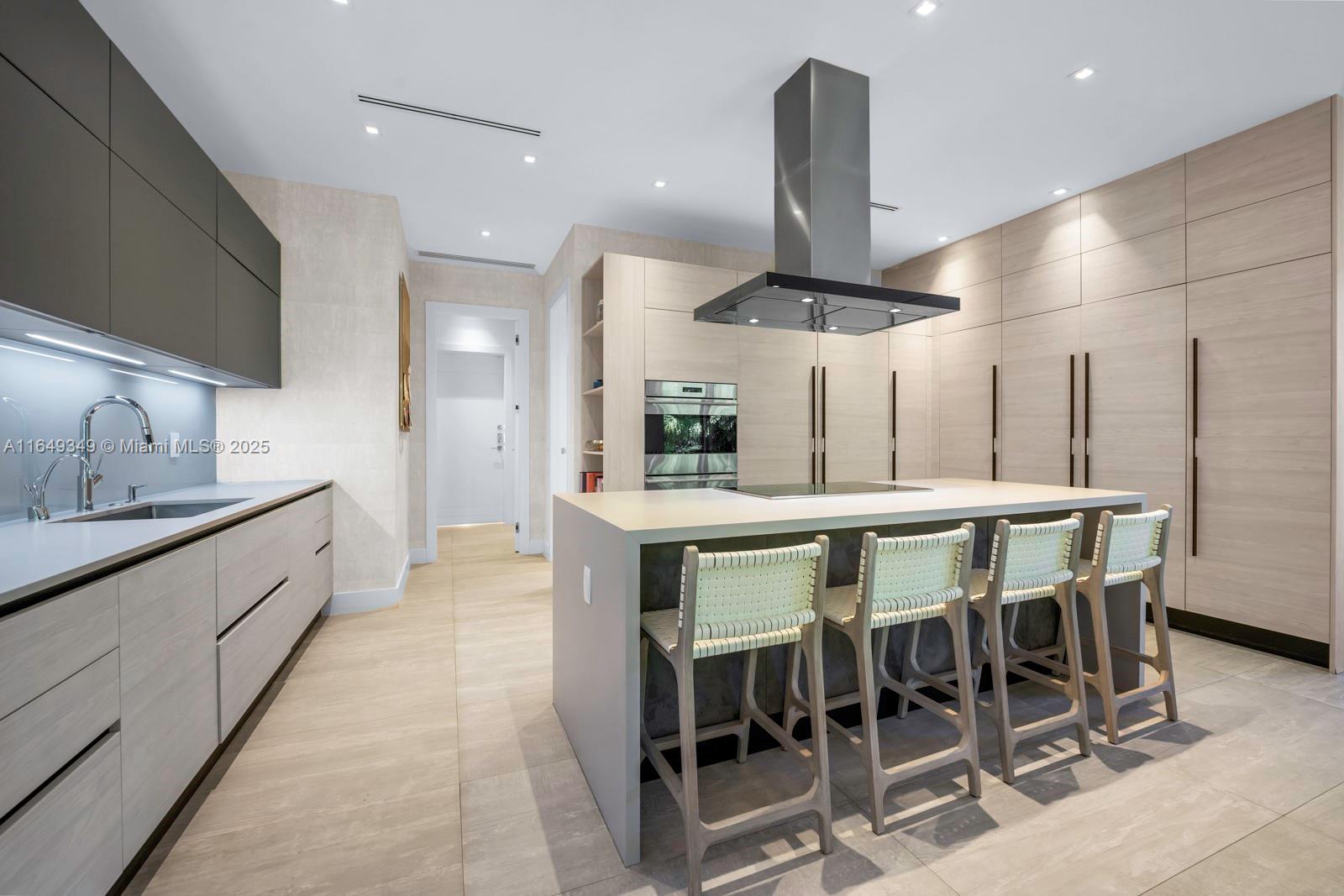 7900 Southwest 54th Avenue Miami, FL 33143 - Photo 23 of 63 a kitchen with stainless steel appliances kitchen island granite countertop a table chairs sink and wooden floor