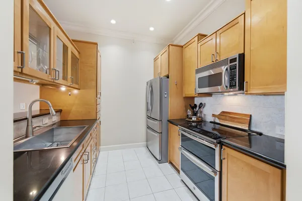 a kitchen with stainless steel appliances granite countertop a refrigerator and a stove top oven