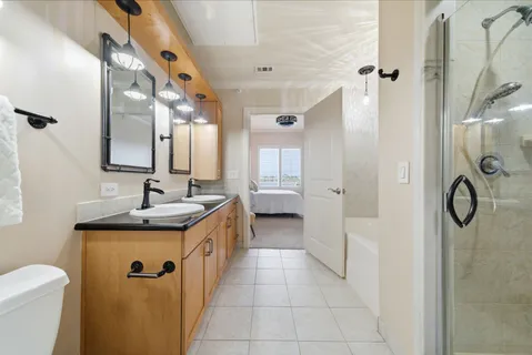 a bathroom with a granite countertop sink a toilet and shower