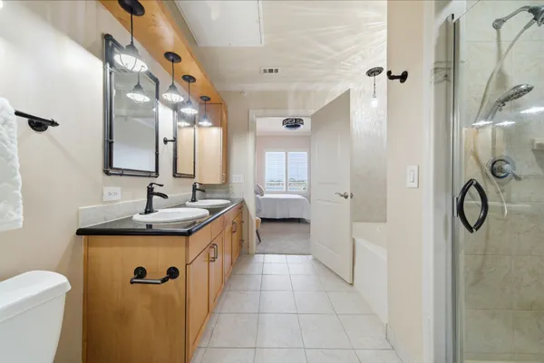 a bathroom with a granite countertop sink a toilet and shower