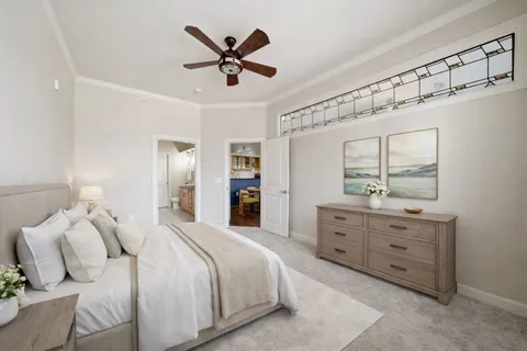 a spacious bedroom with a large bed and a chandelier