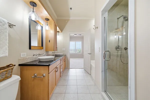 a bathroom with a granite countertop sink a mirror and a shower