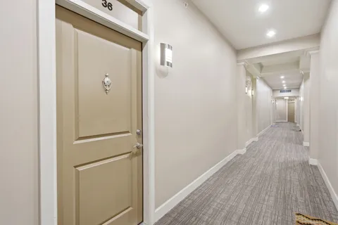 a view of a hallway with wooden floor