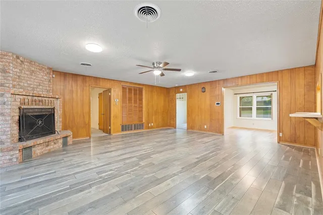 a view of an empty room with a fireplace and a window