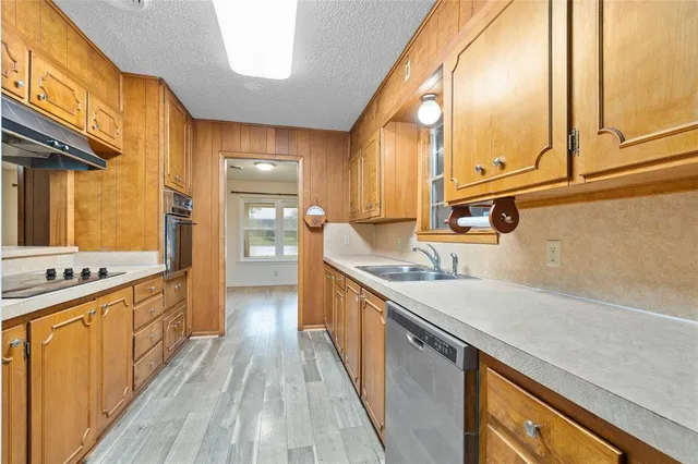 a kitchen with stainless steel appliances granite countertop a lot of counter space and wooden floors