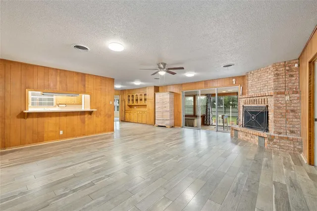 a view of empty room with wooden floor and fireplace