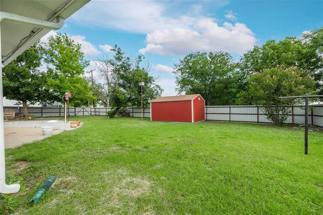 a view of a garden with a bench in the garden