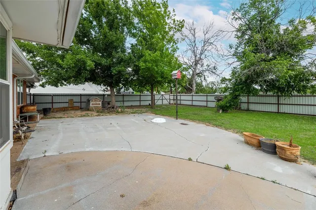 a view of a patio with a table and chairs under an umbrella