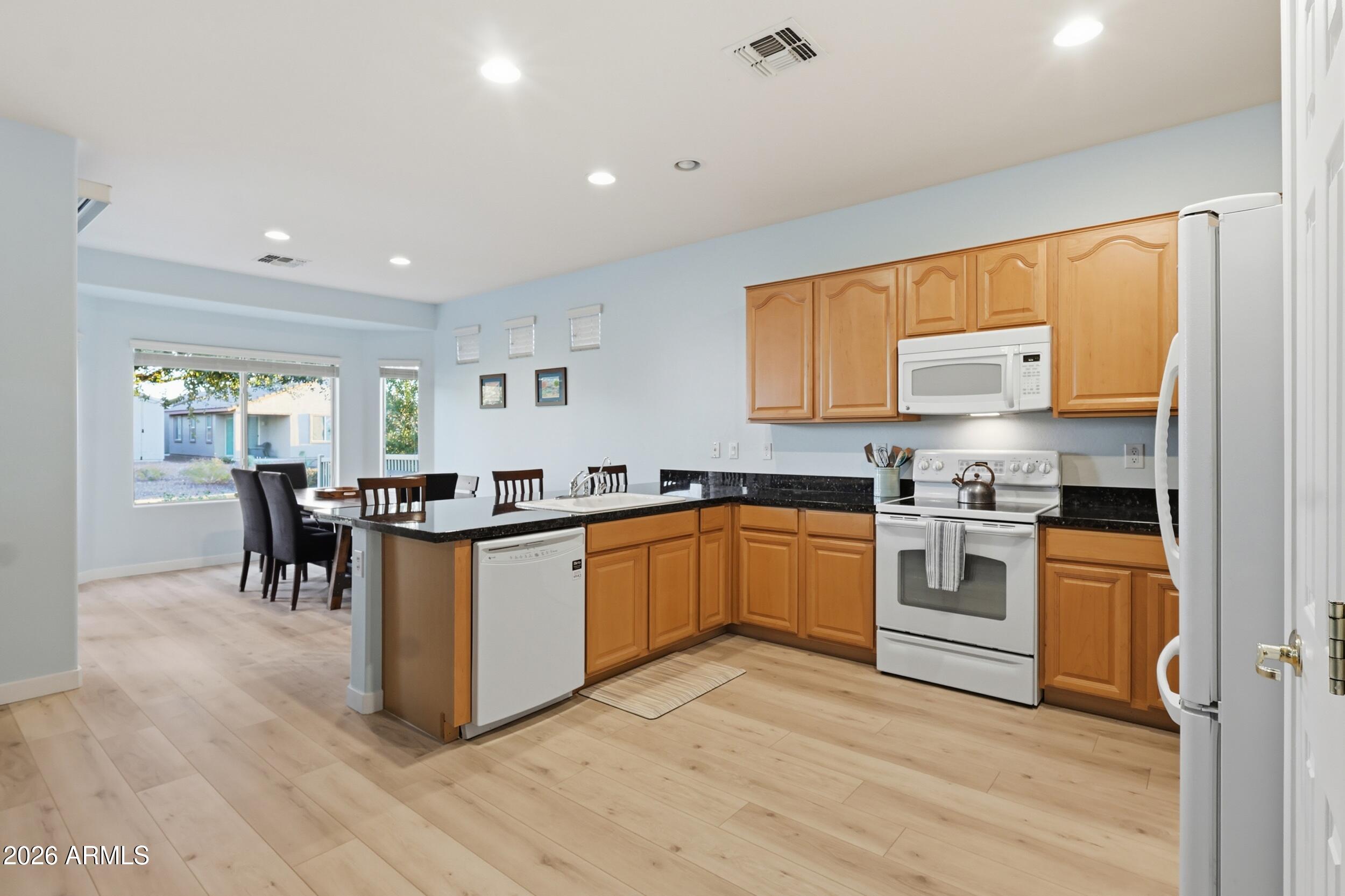 20357 North Lemon Drop Drive Maricopa, AZ 85138 - Photo 15 of 39 a kitchen with granite countertop a stove top oven sink and cabinets