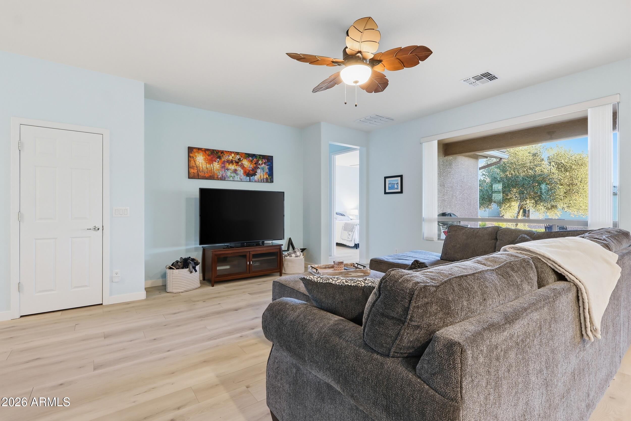 20357 North Lemon Drop Drive Maricopa, AZ 85138 - Photo 8 of 39 a living room with furniture a ceiling fan and a flat screen tv