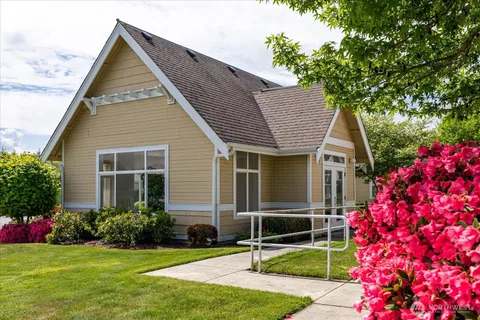 a front view of a house with lots of flowers