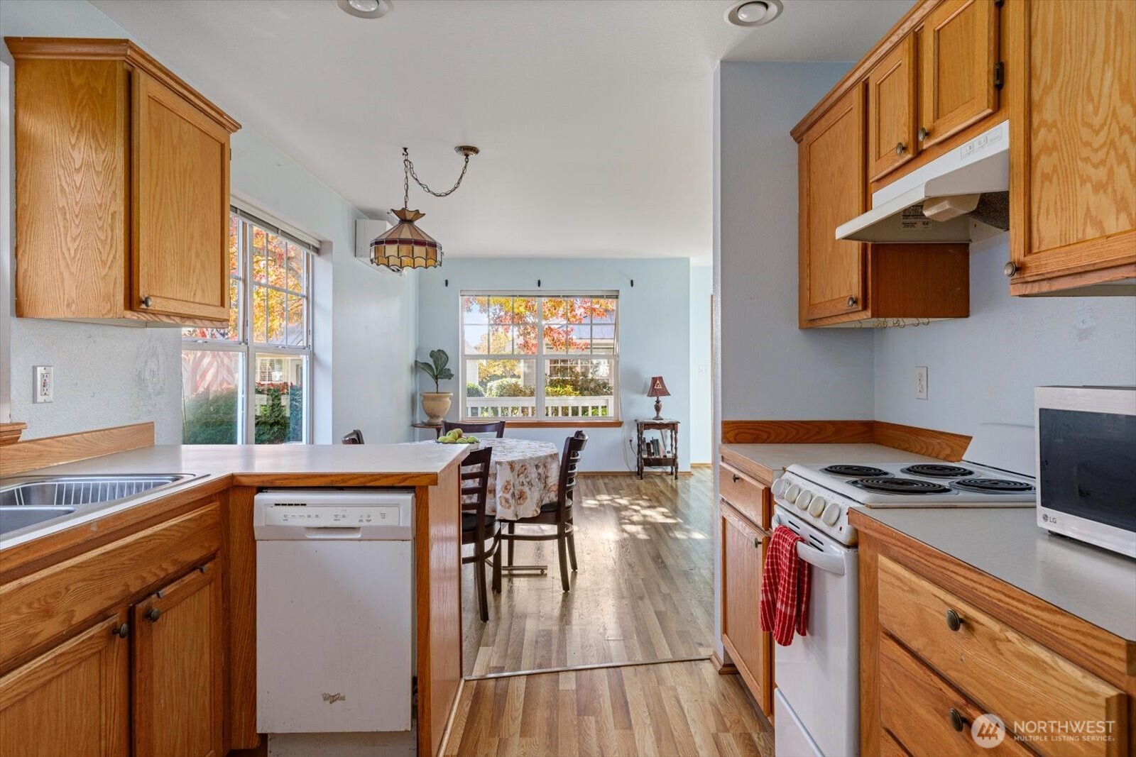 161 West Whidbey Avenue, Unit 5 Oak Harbor, WA 98277 - Photo 4 of 32 a kitchen with stainless steel appliances granite countertop a stove a sink dishwasher and cabinets with wooden floor