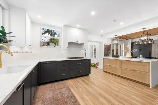 a kitchen with stainless steel appliances kitchen island granite countertop a refrigerator and a sink