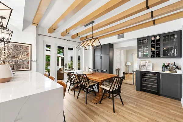 a dining hall with stainless steel appliances a dining table and chairs with wooden floor