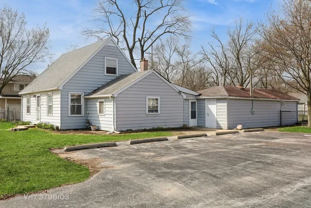a view of a house with a yard and large tree