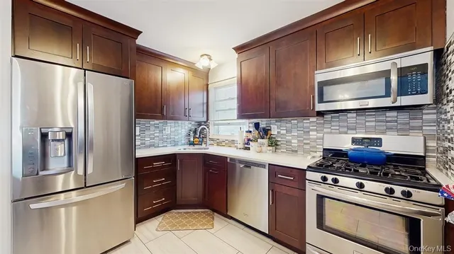 a kitchen with stainless steel appliances granite countertop a refrigerator stove a sink dishwasher and microwave oven