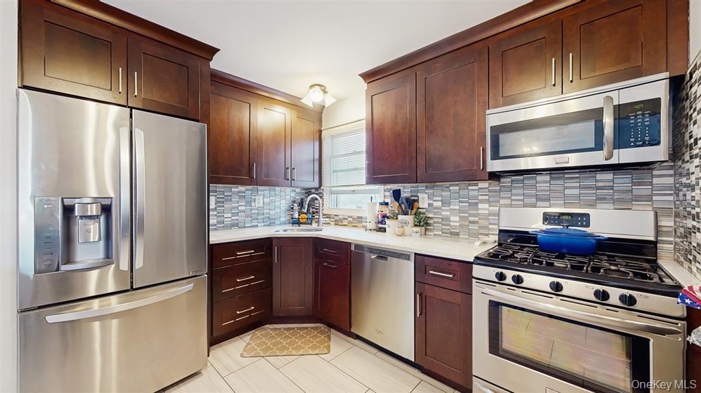 156-40 76th Street, Unit 2 Queens, NY 11414 - Photo 9 of 18 a kitchen with stainless steel appliances granite countertop a refrigerator stove a sink dishwasher and microwave oven