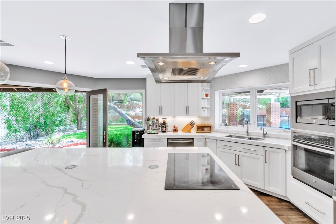 108 Quail Run Road Henderson, NV 89014 - Photo 30 of 50 Kitchen with white cabinets, island exhaust hood, stainless steel appliances, and recessed lighting