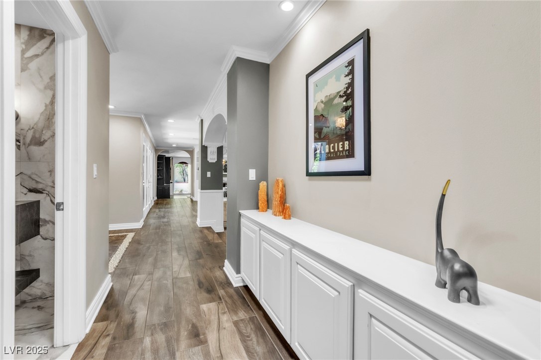 108 Quail Run Road Henderson, NV 89014 - Photo 38 of 50 Hall featuring arched walkways, dark wood-style flooring, recessed lighting, and ornamental molding