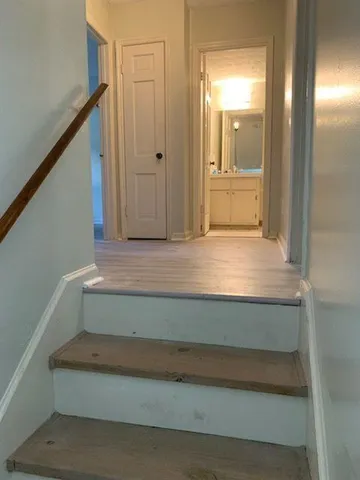 a view of a hallway with wooden floor and chandelier