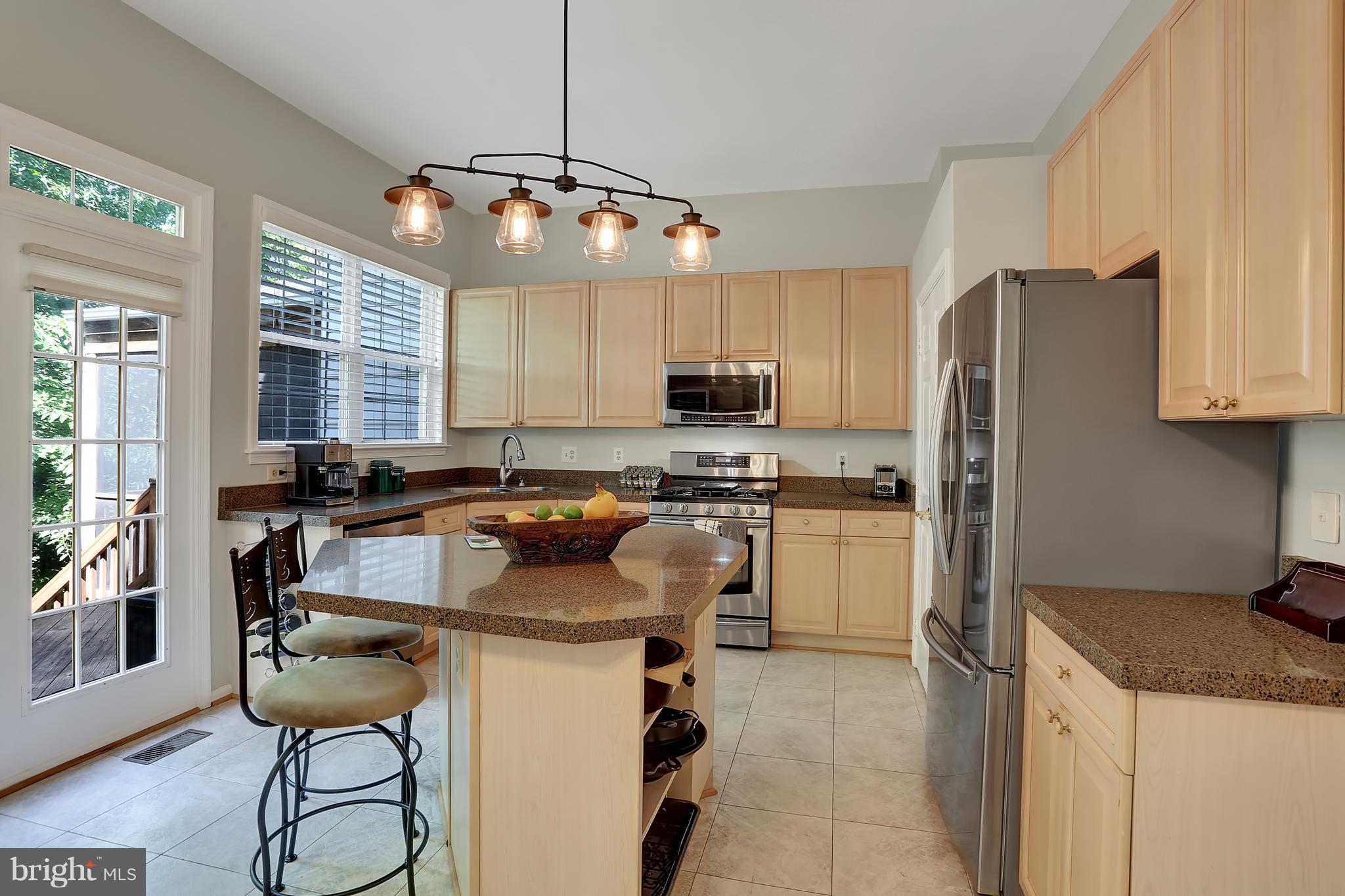 20693 Riptide Square Sterling, VA 20165 - Photo 2 of 30 a kitchen with kitchen island a counter space a sink appliances and cabinets