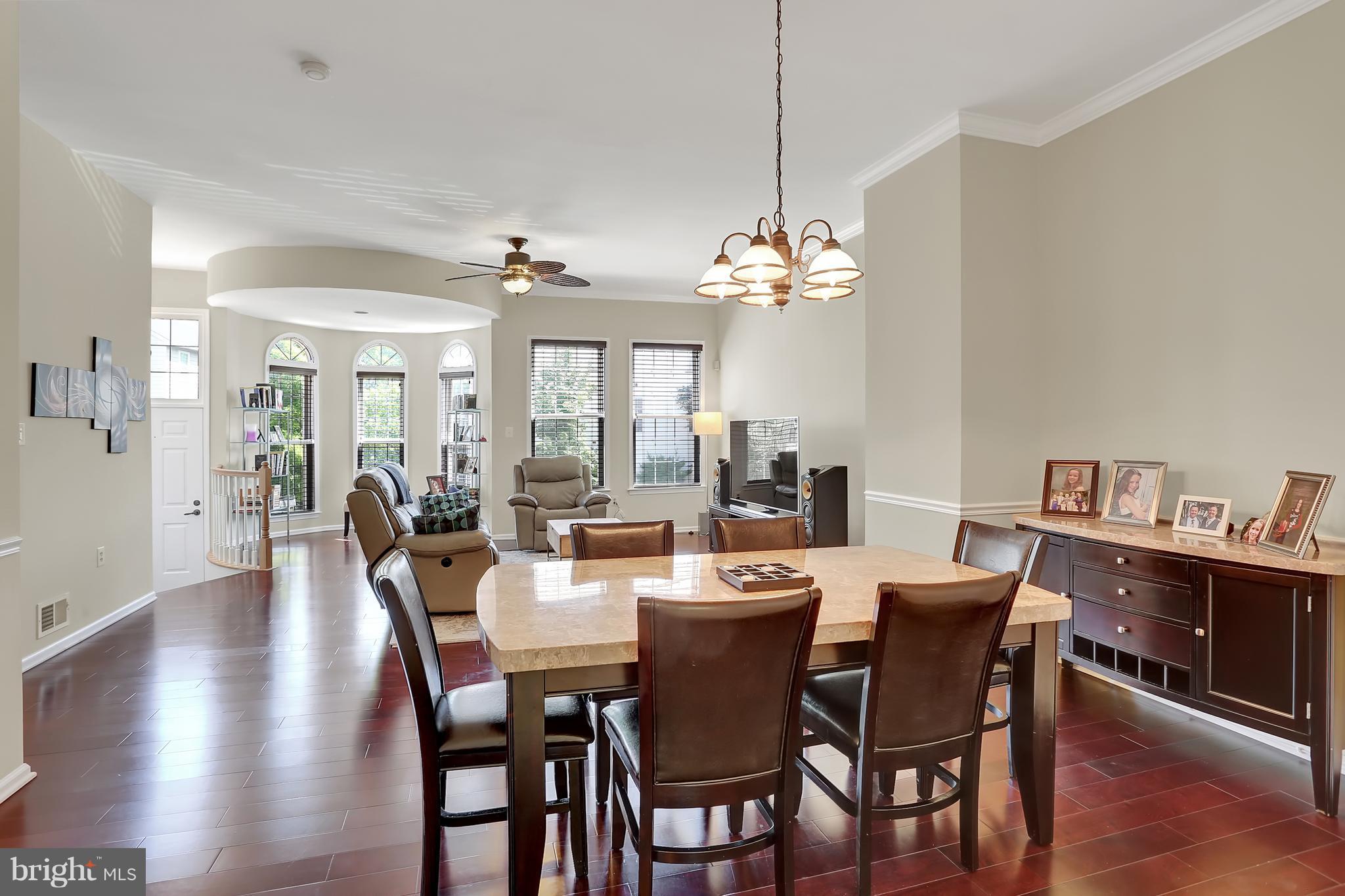 20693 Riptide Square Sterling, VA 20165 - Photo 11 of 30 a dining room with wooden floor a chandelier a wooden table and chairs