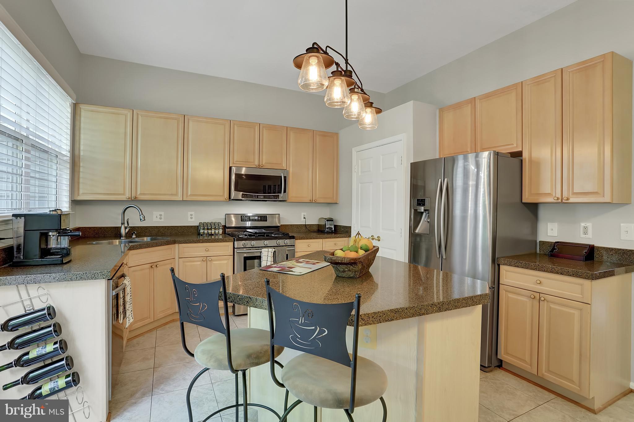 20693 Riptide Square Sterling, VA 20165 - Photo 6 of 30 a kitchen with a refrigerator a stove top oven a sink dishwasher and white cabinets with wooden floor